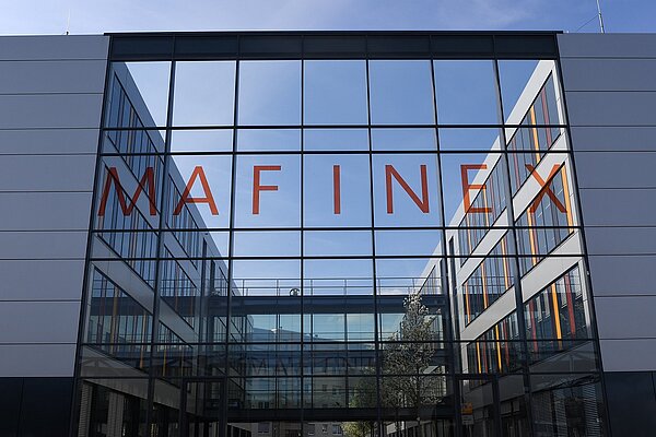 Glasfassade des MAFINEX Gründerzentrums in Mannheim, beklebt mit roten Buchstaben und dem Schriftzug "MAFINEX"