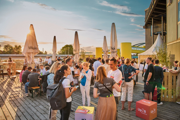 Akteurinnen und Akteure aus der Mannheimer Gründungs-Community vernetzen sich auf einer Terrasse mit kühlen Getränken. 