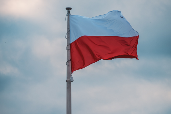 Polnische Flagge an einem Fahnenmast. Die Flagge weht im Wind.