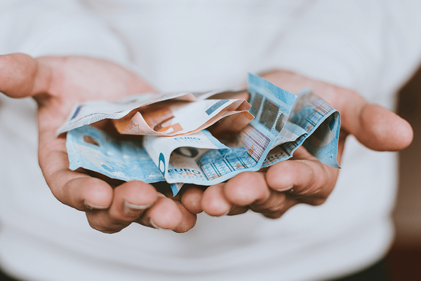 Eine Person hält mehrere Euro-Geldscheine in ihren Handflächen.