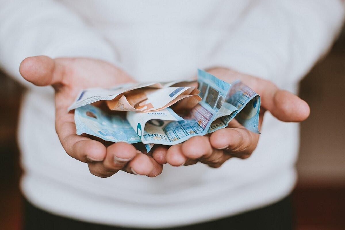 Eine Person hält mehrere Euro-Geldscheine in ihren Handflächen.